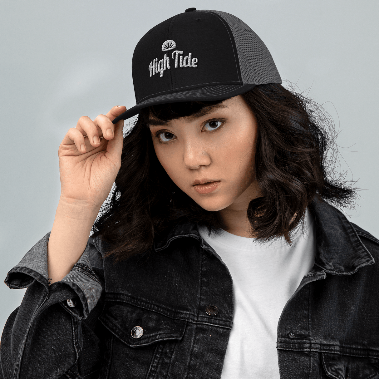 Model wearing High Tide trucker cap with High Tide Papers logo