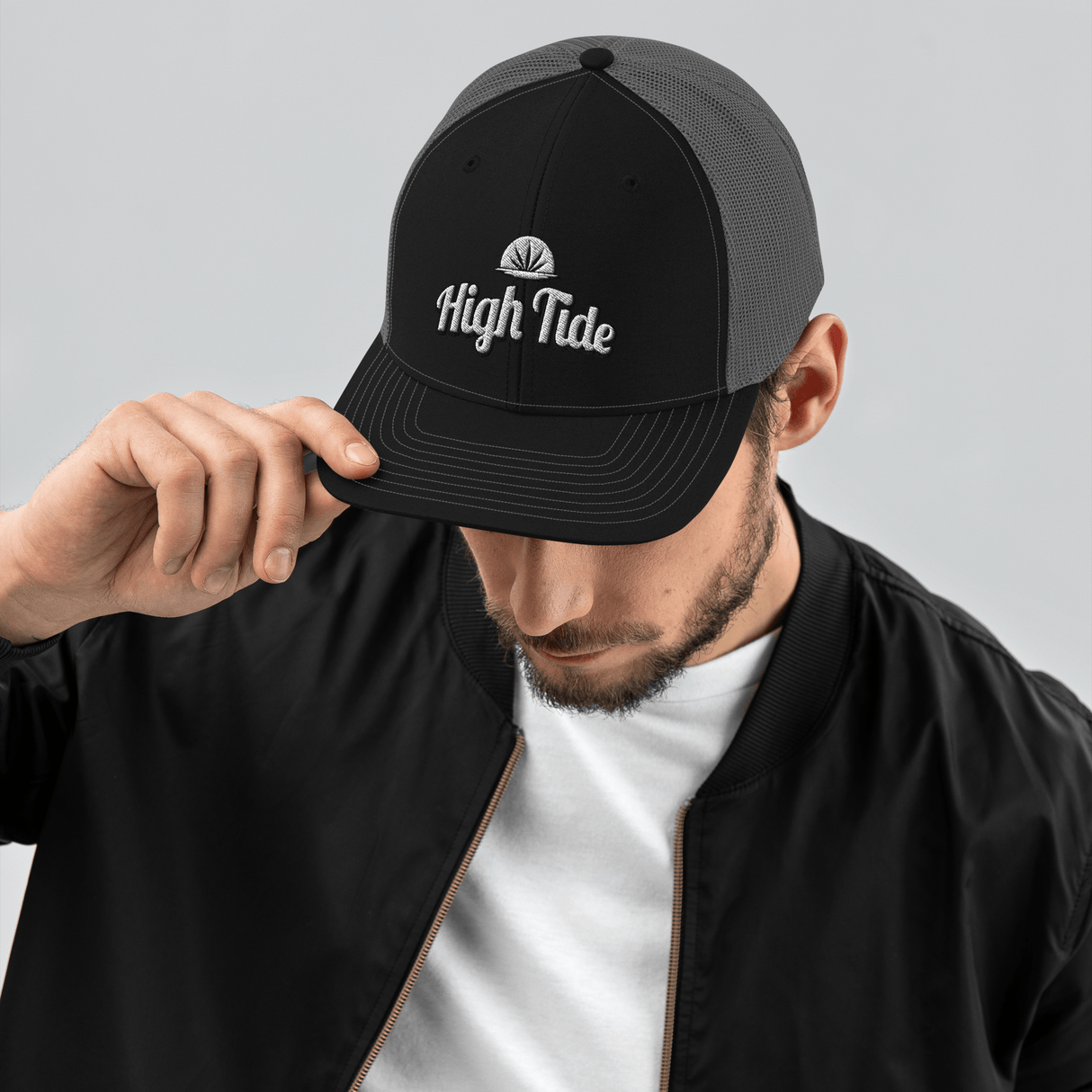 Model wearing High Tide trucker cap with High Tide Papers logo